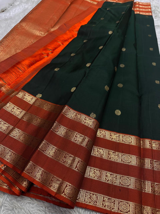 Pachai Mayil Chakram Varisaipet — Pure Kanchipuram Silk Saree
Deep pachai (bottle green) body with antique-gold chakram buttas, rust-vermillion varisaipet borders, and a radiant kesari-orange zari pallu.
Silk Mark Certified • Blouse Stitching Available