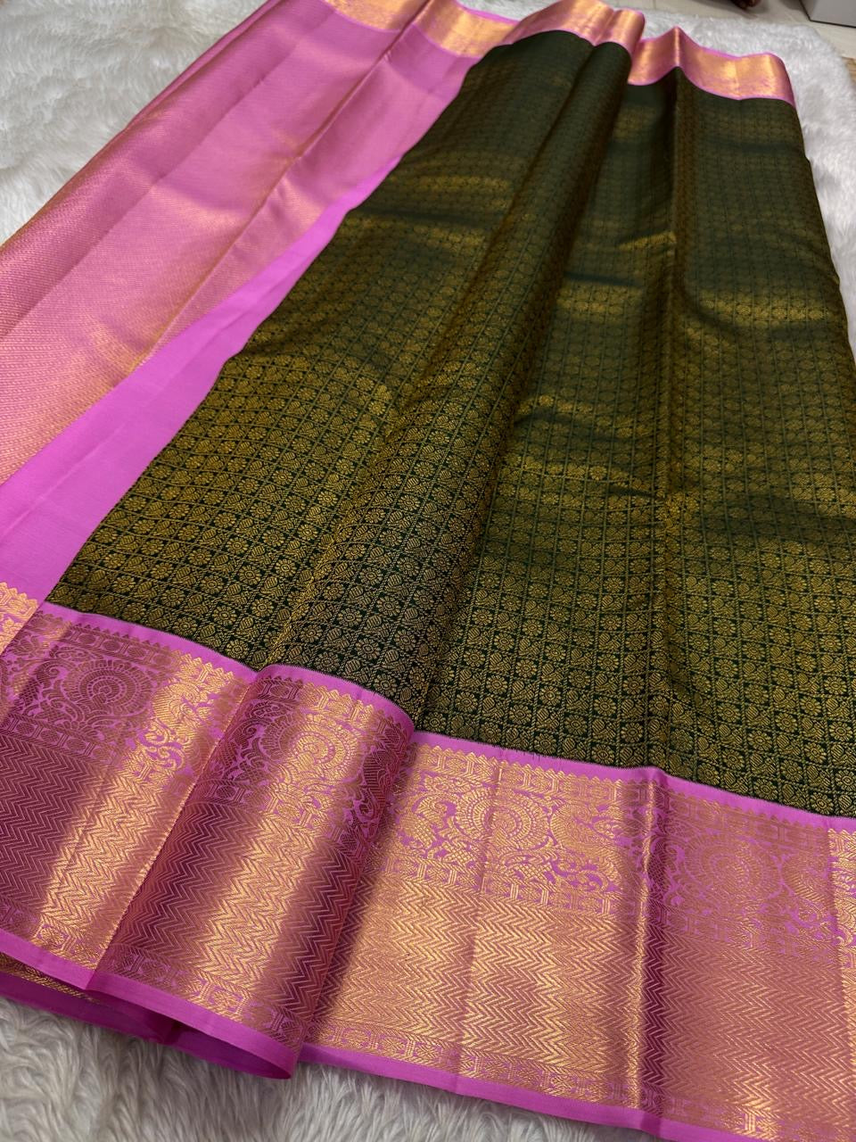 Iniya – Bottle Green & Pink Kanchipuram Pure Silk Saree with Floral Jaal and Mayil Border
Graceful and refreshing, Iniya is a handwoven masterpiece in bottle green with soft pastel pink accents. Delicate floral jaal and mayil motifs dance across the drape
