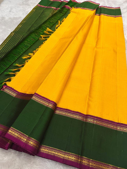 Yellow Kanchipuram silk saree with green border and antique gold zari detailing, folded view