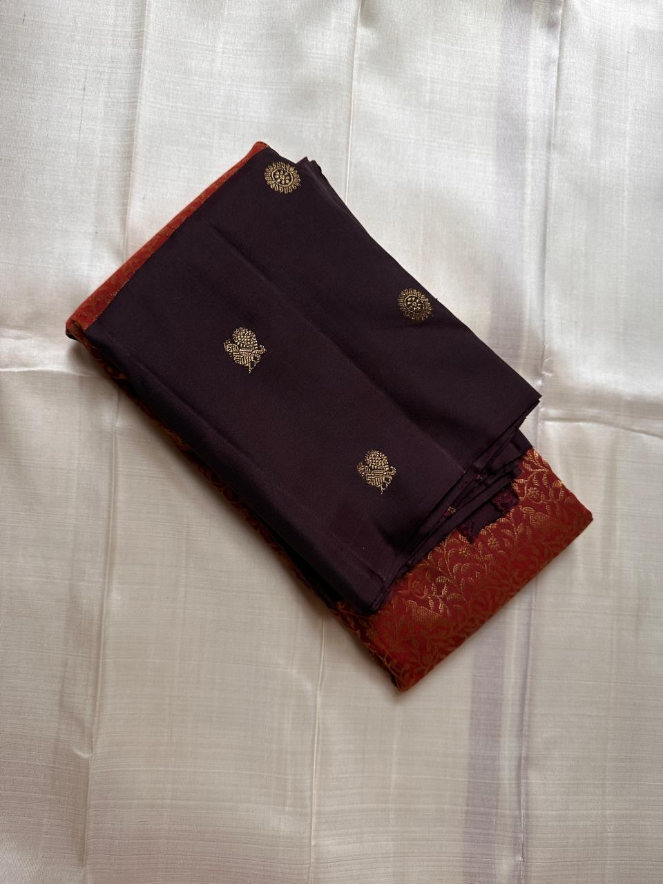 Sudar Mayil – Radiant Burnt Orange Pure Kanchipuram Silk Saree
Lustrous burnt orange body adorned with intricate gold vine jaal.
Broad deep plum borders gleam with antique zari artistry.

Silk Mark Certified, delivery in 2 weeks