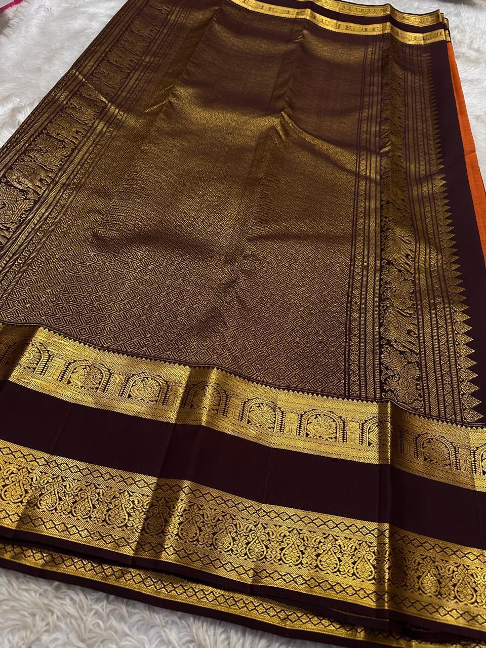 Rust Orange Choodamani — Pure Silk Kanchipuram
Rust-orange body with golden paisley buttas ✨
Deep maroon korvai borders with temple-arch zari 🌸
Grand maroon brocade pallu with elephants & florals 🪔
Silk Mark Certified • Free Shipping USA • Ships in Two