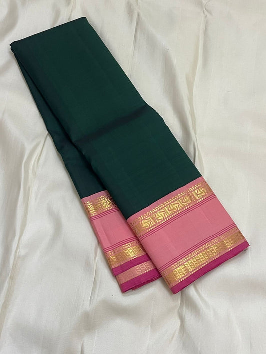 Adar pachai green pure Kanchipuram silk saree laid flat showing wide lotus pink rettapet zari border