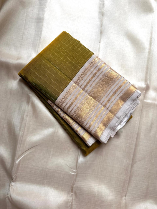 Luminous Lemon-Olive Green — White Korvai Kanchipuram

Pure Silk | Vairaoosi Checks | Korvai Contrast Borders

Classic White & Gold Pallu with Coin Jaal Motifs

Perfect for Muhurtham, Haldi & Temple Occasions

Silk Mark Certified | Free Shipping | Shi
