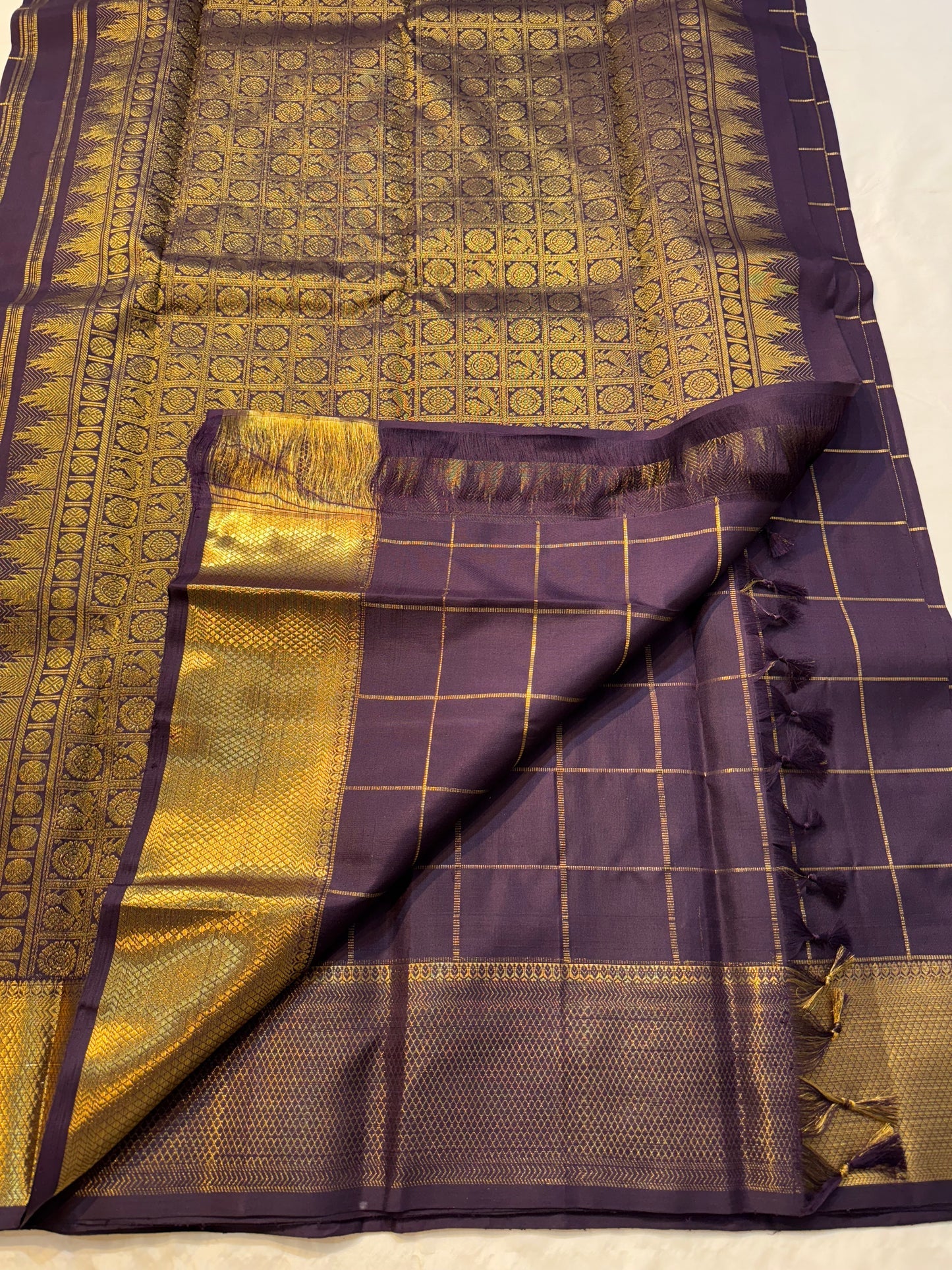 Plum Zari Kattam — Pure Kanchipuram Silk Saree
Rich plum body with gold kattam grid & Gandaberunda buttas ✨
Antique-gold brocade border & grand zari pallu • Silk Mark Certified • Free Shipping within USA • Ships in Two Weeks