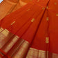 Close-up of red Kanchipuram silk saree with dense gold zari weaving along the border and body.