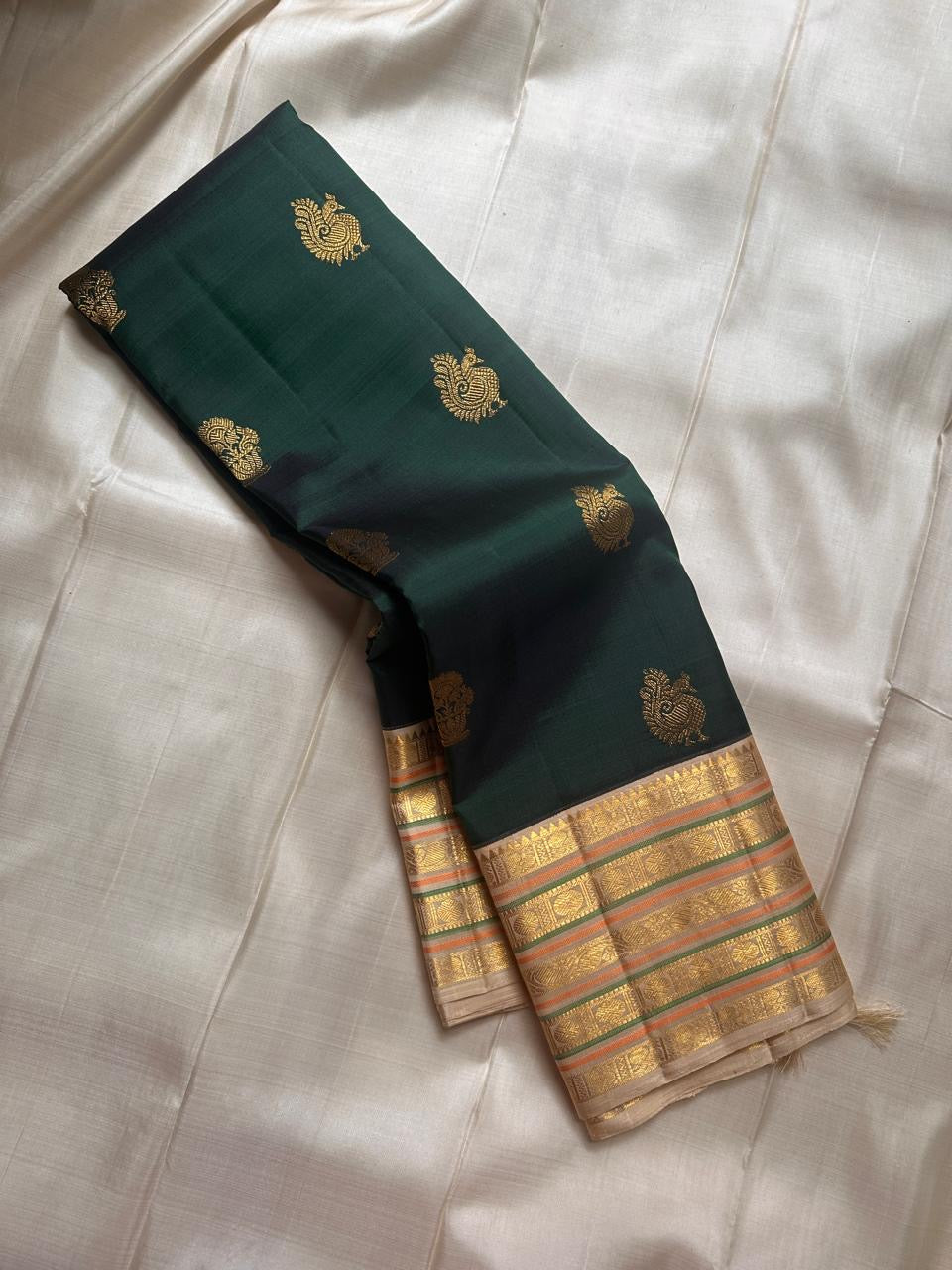 Maragatham 💚✨ – Emerald Green Pure Kanchipuram Silk Saree with Handwoven Gold Peacock Buttas 🦚, Ivory-Gold Varisaipet Zari Border 🌿💛 & Ornate Traditional Pallu with Hand-Knotted Tassels 🎀