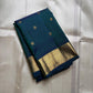 Folded peacock teal Kanchipuram silk saree with gold zari buttas and wide zari woven border