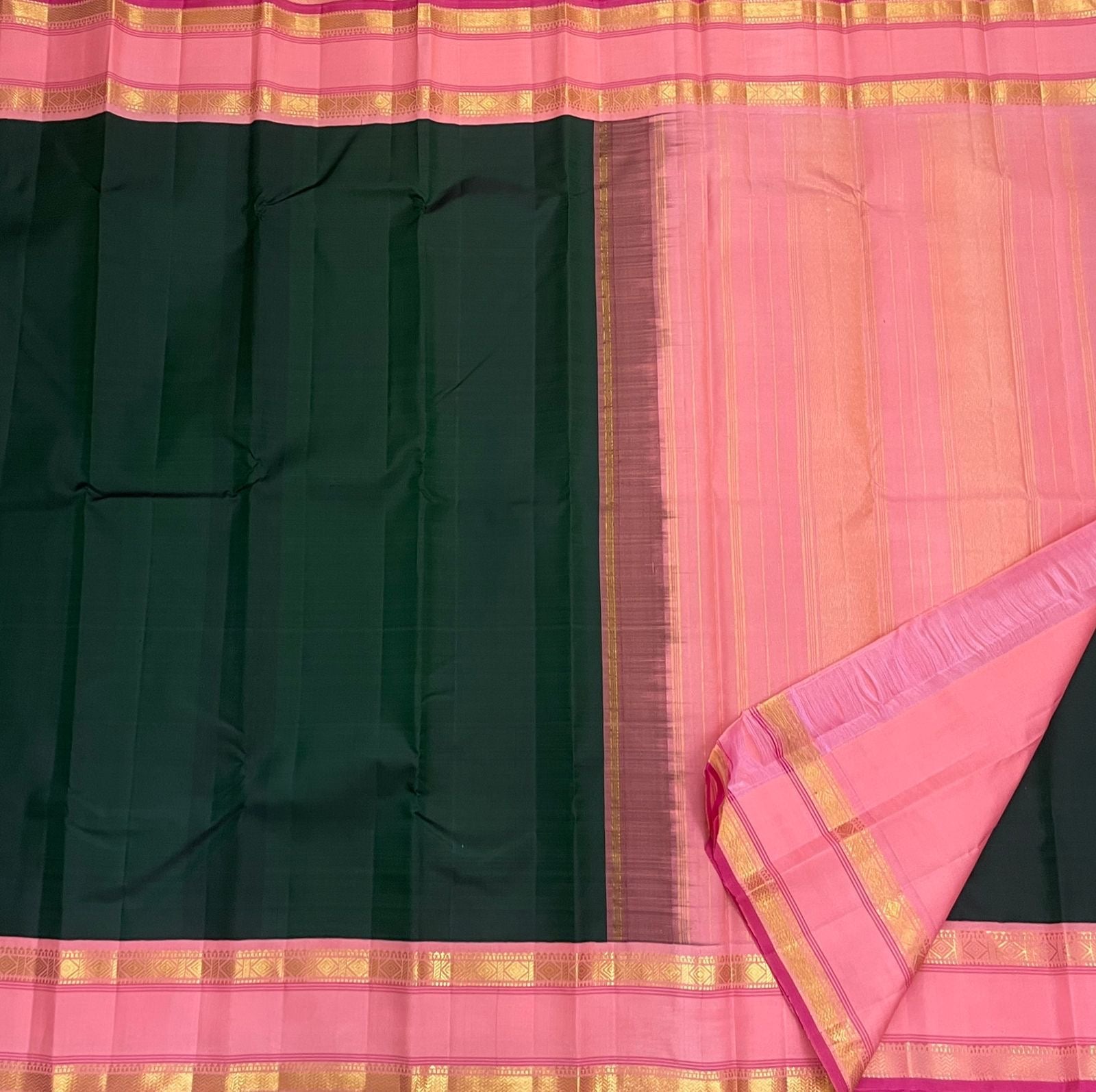 Full saree flat lay with Adar pachai green body and thamarai pink pallu with gold zari stripes, available in the USA