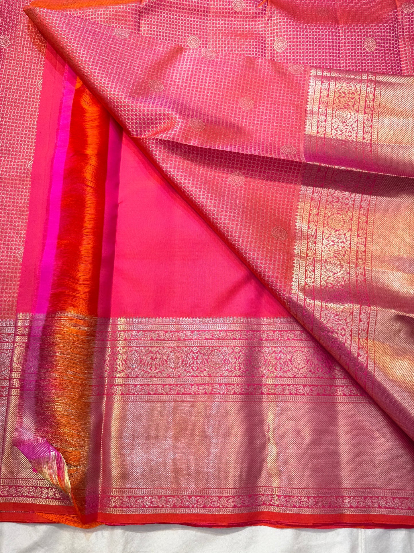 Peach Pink Flower Butta – Coral-pink shot body with micro checks & floral buttas

Handwoven Kanchipuram silk with delicate copper-pink zari work

Elegant floral vines on borders • grand rose-gold brocade pallu

Silk Mark Certified | Fall & Pico Done |
