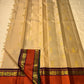 Flat-lay pure Kanchipuram silk saree in biscuit beige with scattered gold buttas and rust orange zari woven border, shipped from New Jersey USA