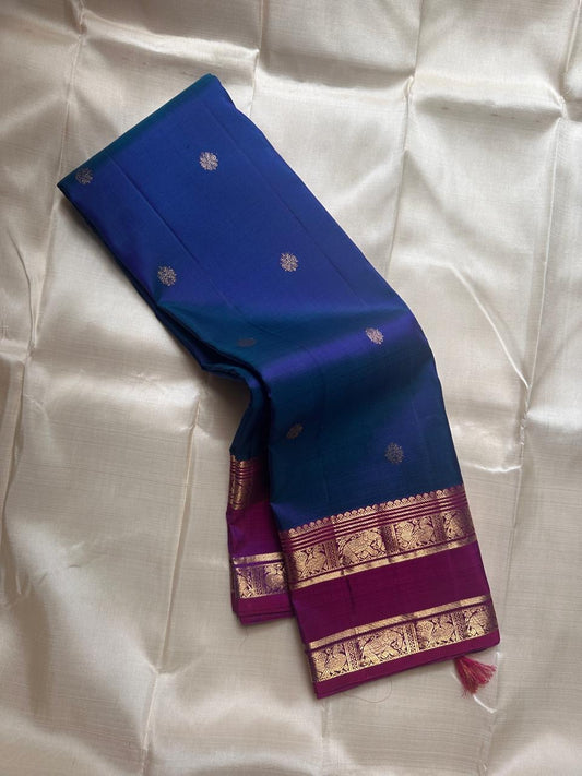 Purple Allure – Pure Kanchipuram Silk Saree
Peacock-blue body adorned with petite zari floral buttas 🌸
Contrast royal-purple border with grand elephant procession 🐘
Rich zari brocade pallu in floral motifs ✨

Silk Mark Certified, delivery in 2 weeks