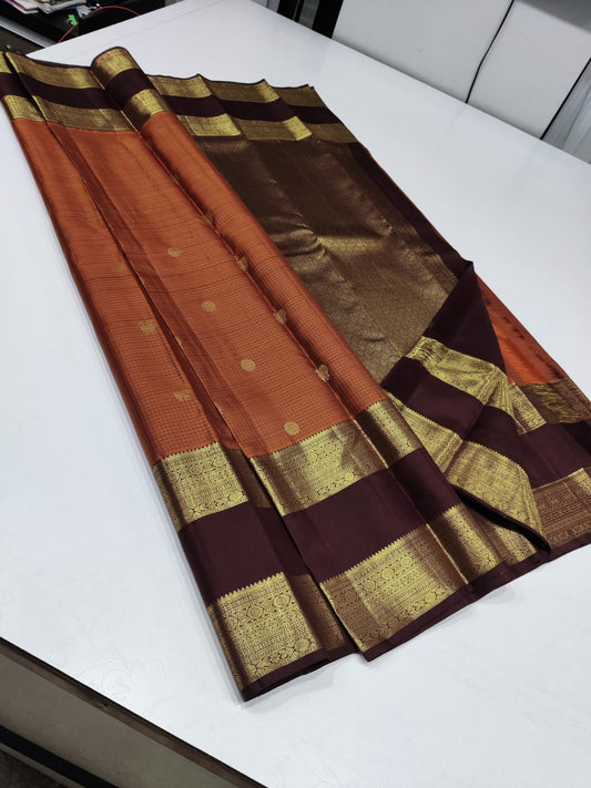 Burnt orange pavun butta – Pure Kanchipuram Silk Saree
Burnt Orange  body adorned with delicate kattam checks ✨
Scattered gold medallion buttas add timeless temple elegance

Silk Mark Certified, delivery in 2 weeks
