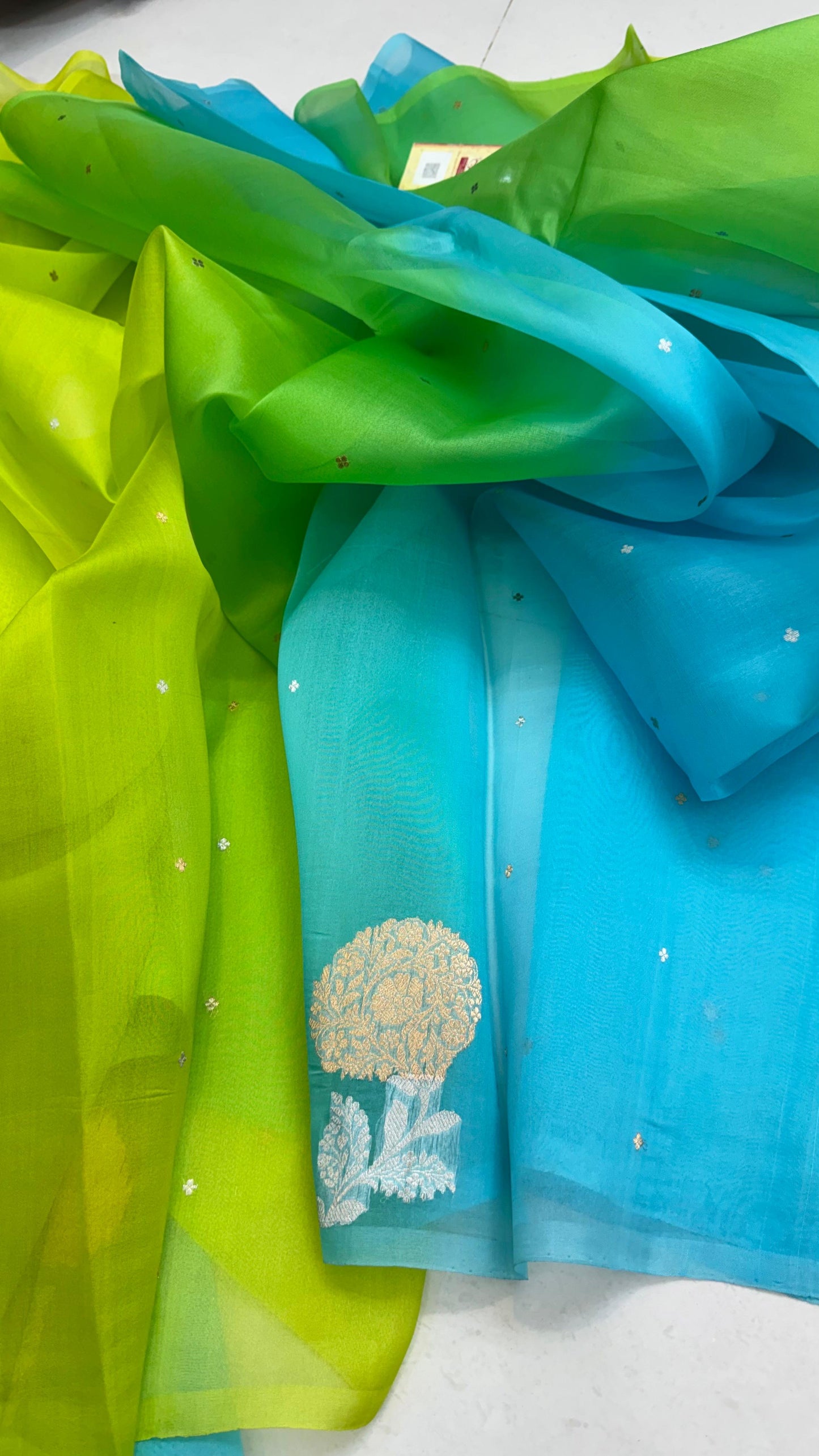 Pure Ektara Kora Silk Handloom Banarasi Saree
Parrot green to aqua blue ombré • Kadhua sona-roopa floral buttas • Raw-Mango style minimal weave
Silk Mark Certified ✅ • Free USA Shipping ✅ • ships in two weeks ✅