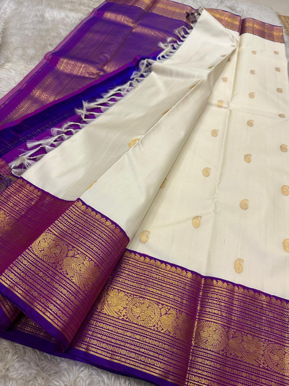 Hamsa Paisley — Pure Handloom Kanchipuram Silk Saree 
Ivory Body with Gold Paisley Buttas & Royal Purple Brocade Border ✨
Silk Mark Certified • free shipping within Usa ships in two weeks