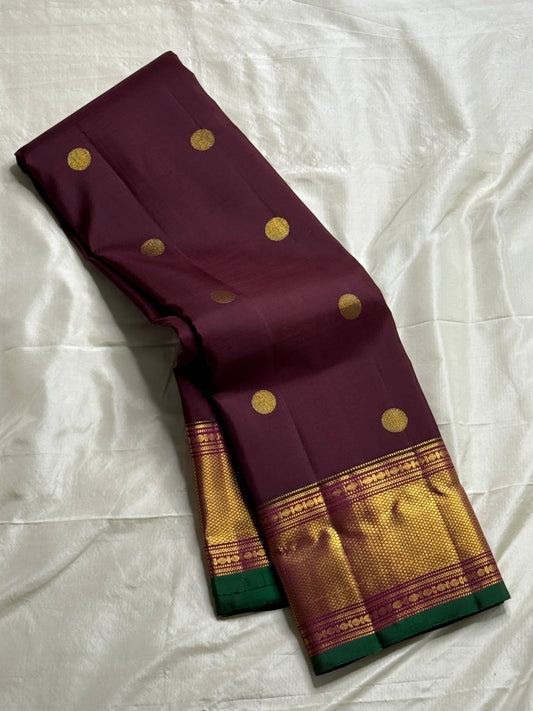 Plum & Magenta Round Butta – Pure Kanchipuram Silk Saree
Deep plum body with bold round gold zari buttas
Contrast green selvedge & gold tissue borders with magenta detailing
Grand magenta-pink pallu with full zari diamond jaal & geometric panels
Silk Mark