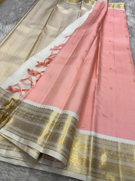 A serene blend of blush pink and pure white — soft, graceful pure silk Kanchipuram with kamalam zari butta and bavanji border and Pallu in cream