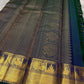 A celestial blend of blue and green, this Kanjivaram silk saree ,adorned with Gandaberunda and Kamalam buttas, golden checks, and a majestic thazhampoo Mayil  border. Zari kattam