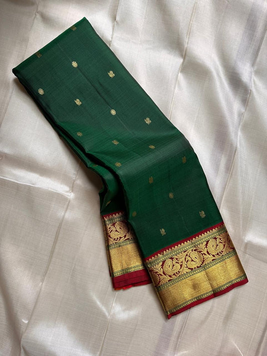 Emerald Glow ✨ – Pure Kanchipuram Silk Saree

Deep Green Body with Gold Floral Buttas

Maroon Korvai Border with Peacock & Floral Zari Motifs

Grand Gold Zari Brocade Pallu with Diamond Lattice Weave

Silk Mark Certified | Fall & Pico Done | Blouse Stitch