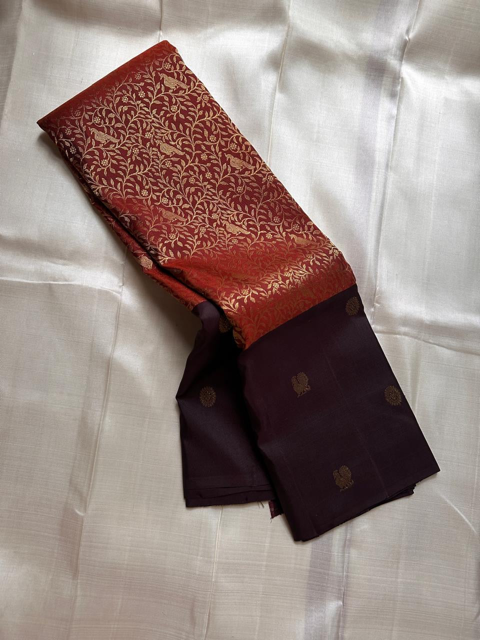 Sudar Mayil – Radiant Burnt Orange Pure Kanchipuram Silk Saree
Lustrous burnt orange body adorned with intricate gold vine jaal.
Broad deep plum borders gleam with antique zari artistry.

Silk Mark Certified, delivery in 2 weeks