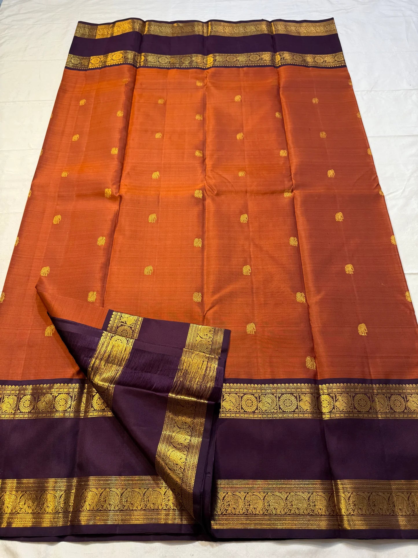 Poovizhi Rust Orange — Pure Kanchipuram Silk Saree
Deep aubergine body with rust-orange korvai borders & rich zari floral motifs
Silk Mark Certified • Blouse Stitching ($30) • Free Shipping within USA • Ships in Two Weeks
