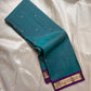Teal pure Kanchipuram silk saree with small gold butti and a purple zari woven floral border.