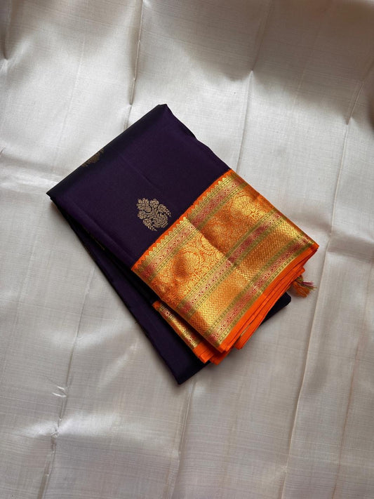 Jamun Purple Kesar – Korvai Kanchipuram Pure Silk Saree

Regal jamun-purple body adorned with antique-gold floral buttas

Kesari-orange korvai border with chakra roundels, vines & chevron zari

Free shipping withinUSA silk mark certified ships in 2 weeks