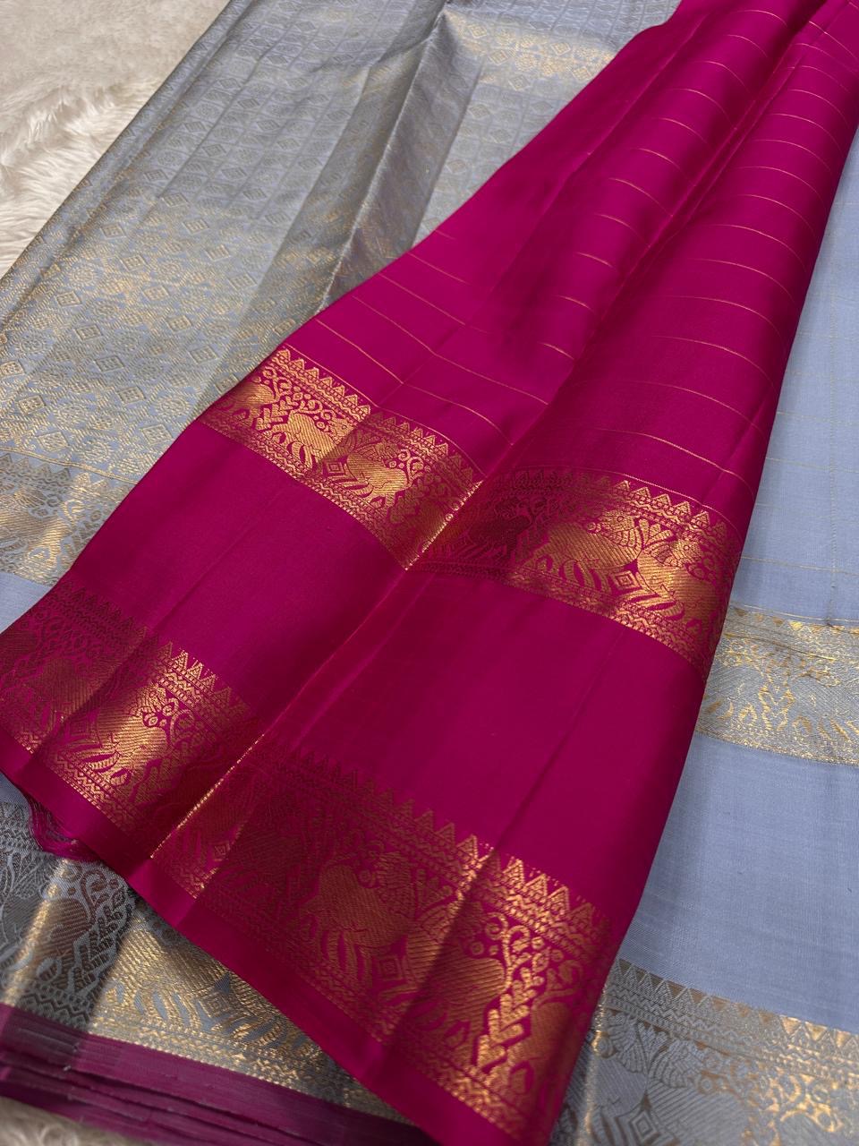 Fuchsia in Sky – Pure Silk Kanchipuram Saree
Sky Blue Body with Gold Kattam Checks & Petite Buttas
Fuchsia Contrast Petni Pallu with Zari Reku Stripes
Wide Gold Zari Border with Peacock & Temple Motifs
Silk mark certified, ships in 2 weeks