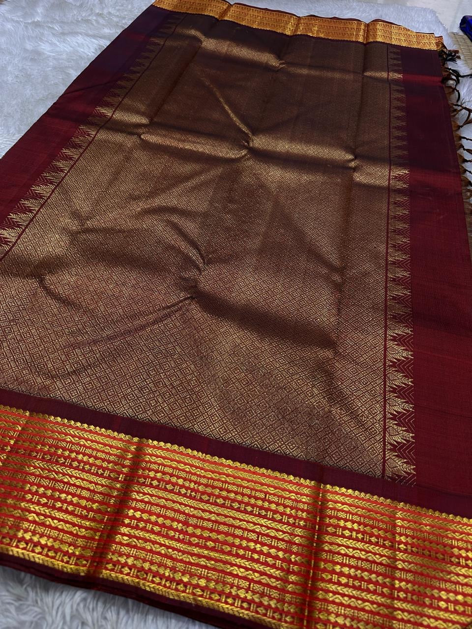 Taupe Glow – Pure Kanchipuram Silk Saree
Ash Taupe Grey Body with Lilac Undertone
Intricate Devadatta Flying Horse Motif in Zari
Deep Maroon Varisaipet Border with Rich Contrast
Grand Zari Pallu with Thazampoo Temple Motifs
