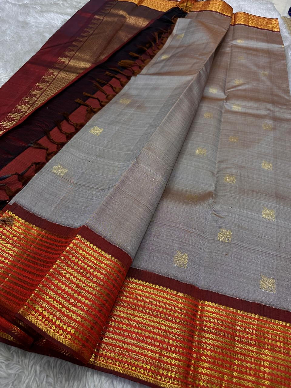 Taupe Glow – Pure Kanchipuram Silk Saree
Ash Taupe Grey Body with Lilac Undertone
Intricate Devadatta Flying Horse Motif in Zari
Deep Maroon Varisaipet Border with Rich Contrast
Grand Zari Pallu with Thazampoo Temple Motifs