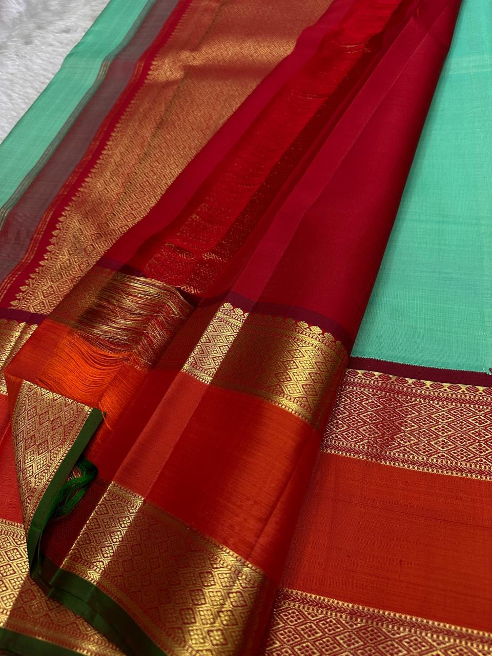 Poomugam Pachai
Pure Silk in Tender Mint & Kumkum Red
Zari-Woven Grandeur in korvai  Contrast