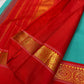 Pure Kanchipuram silk saree in Rama green with vibrant red kaal erangina border and intricate gold zari work, displayed partially open.
