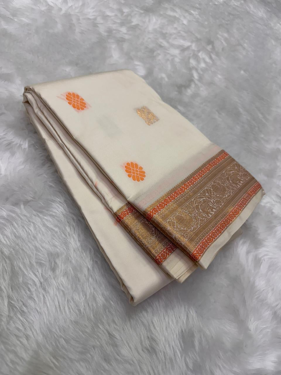 Ivory Swarna — Pure Kanchipuram Silk Saree
Ivory body with marigold rosette and antique-gold paisley buttas, framed in champagne-gold elephant brocade borders.
Silk Mark Certified • Free Shipping within USA • Dispatch in 1 Week • Ships in Two Weeks ✅