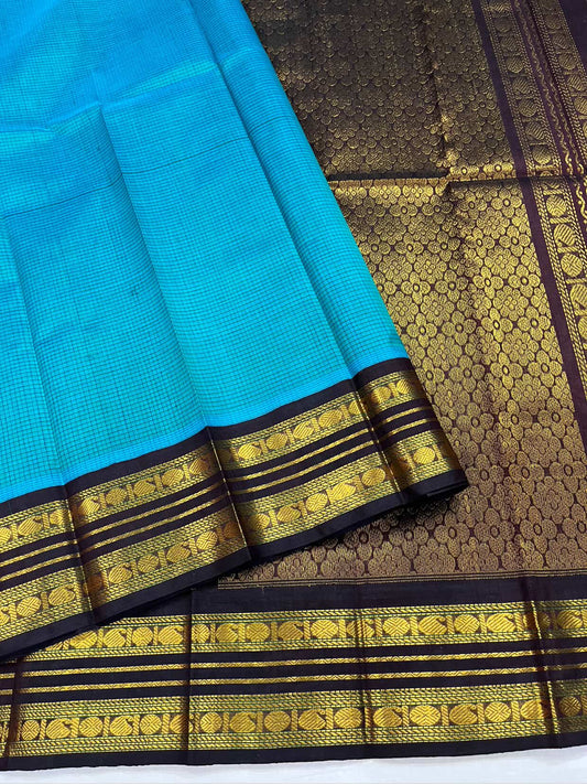Silk Cotton Saree with Turquoise Kattam Body & Maroon Zari Pallu
Turquoise body woven in fine kattam checks.
A maroon contrast border with bold zari bands.
Golden motifs bring structure and elegance.
A floral zari jaal pallu for a festive finish.