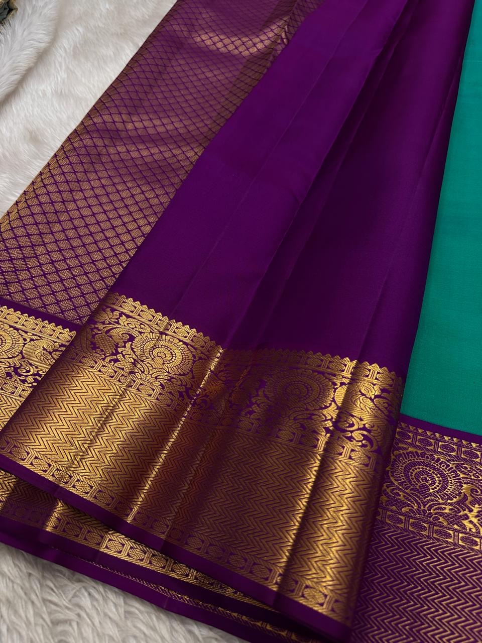 Sindhu- Teal & Purple Kanchipuram Pure Silk Saree with Floral Jaal & Mayil Border
A rich teal base adorned with delicate floral jaal and regal purple mayil borders creates timeless elegance. The diamond-motif pallu adds a bold, sophisticated finish to th