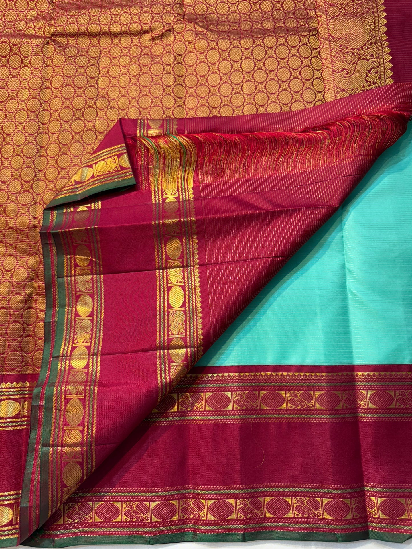 Neer Pachai Vairaoosi — Kanchipuram Pure Silk saree 

Sea-foam/aqua body with classic Vairaoosi pinstripes

Contrast ruby-maroon korvai borders with gold chakram & floral panels

Grand maroon pallu with all-over chakram jaal and paisley vines; aqua tassel