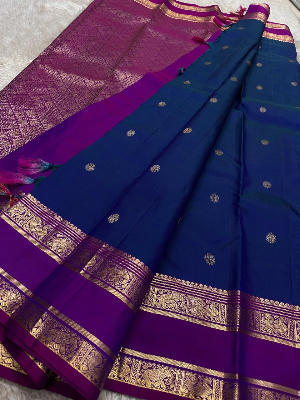 Royal blue Kanchipuram silk saree spread with purple zari pallu and gold border detailing