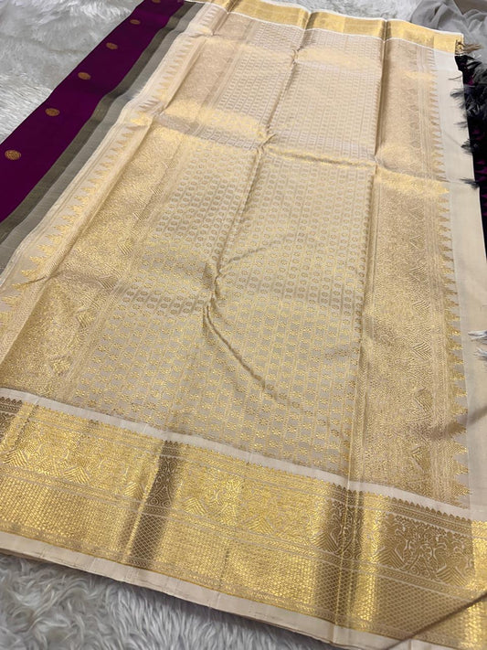 Varuni — Deep Purple & Magenta Shot Kanchipuram Silk Saree
Gold Zari Peacock Motifs on Luxurious Pure Silk
Antique Gold Korvai Border with Gandaberunda Design
Intricate Temple-Inspired Pillayar Moggu Detailing
Silk mark certified