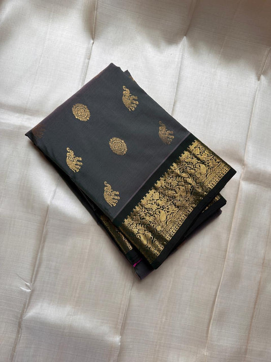 Charcoal Pachai Yaanai – Pure Korvai Kanchipuram Silk Saree
Charcoal grey body with gold zari yaanai & medallion buttas
Deep pachai korvai border with peacock & vine motifs; grand brocade pallu
Silk Mark Certified | Fall & Pico Done | ship in two weeks