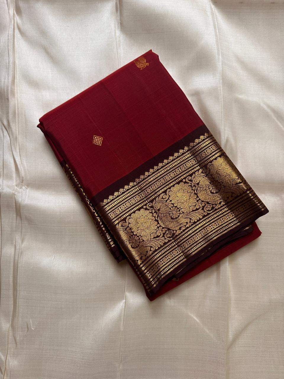 Sienna Red Mayuri Butta — Pure Kanchipuram Silk
Sienna-red body with zari mayuri buttas & antique gold border
Contrast coffee-brown pallu in rich zari jaal • Silk Mark Certified • Free USA Shipping
