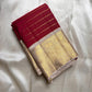 Folded ivory and red Kanchipuram silk saree with gold temple zari border on a cream backdrop