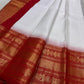 A true festival essential white with dashing red pure silk Kanchipuram saree with a kamalam and mayil detailed border zari work , red reku and Pallu
