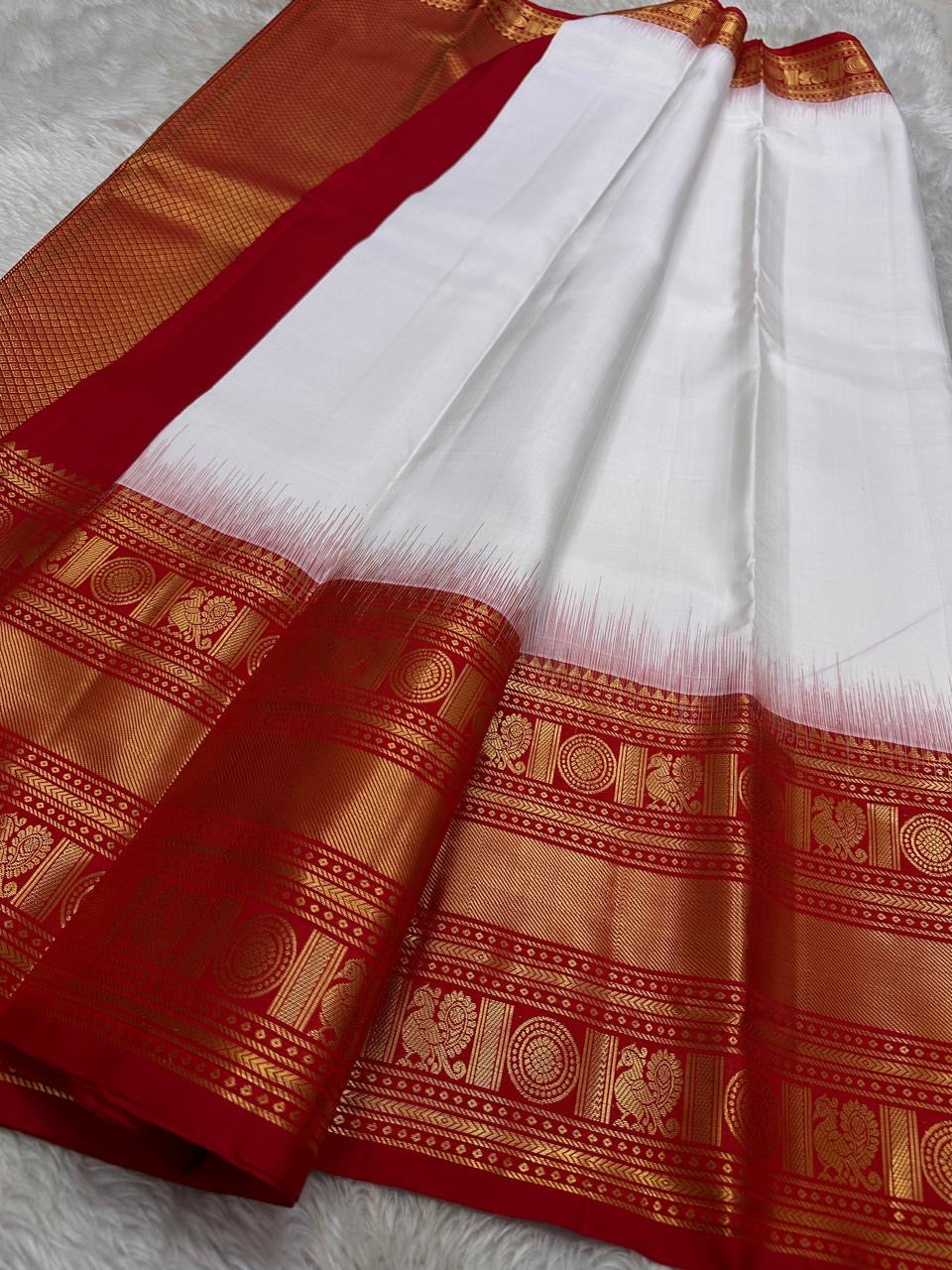 A true festival essential white with dashing red pure silk Kanchipuram saree with a kamalam and mayil detailed border zari work , red reku and Pallu