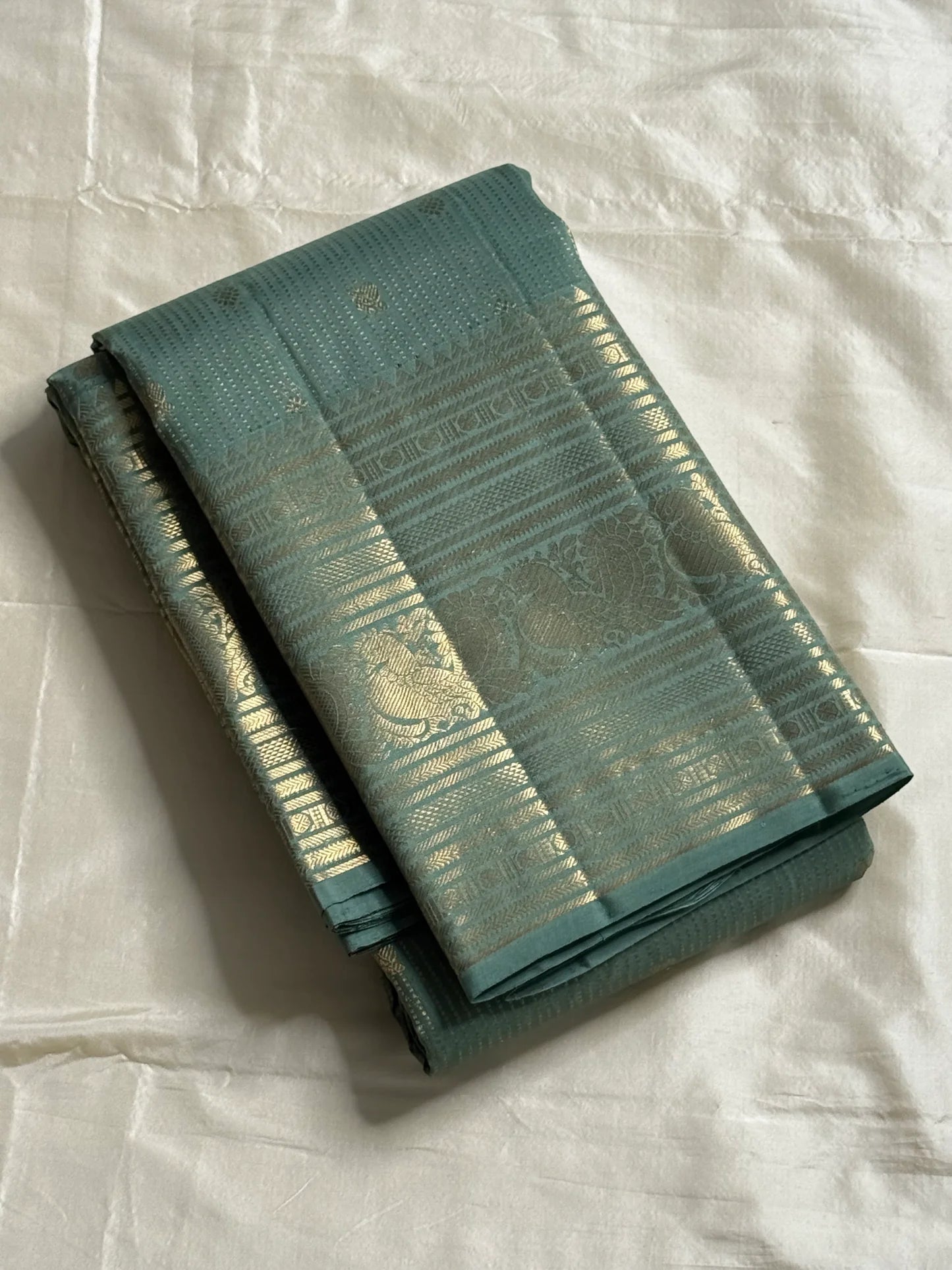 Muted sea-jade/duck-egg green body with fine oosi (pin) stripes

All-over tiny rosette/coin buttas for a soft shimmer

Silk Mark Certified | Free Shipping within USA | Ships in Two Weeks. Blouse Stitching ($30)