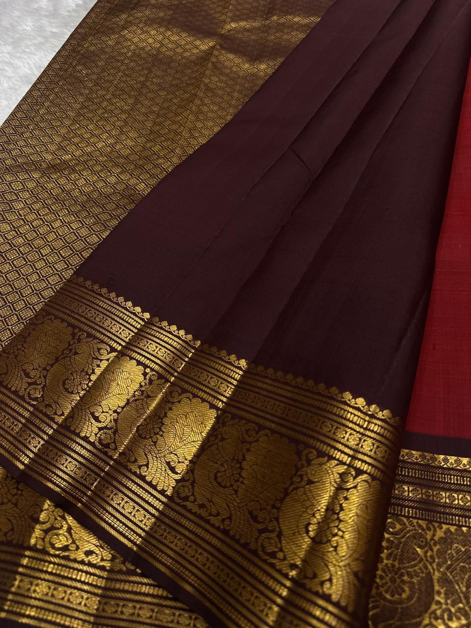 Sienna Red Mayuri Butta — Pure Kanchipuram Silk
Sienna-red body with zari mayuri buttas & antique gold border
Contrast coffee-brown pallu in rich zari jaal • Silk Mark Certified • Free USA Shipping