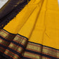 Folded yellow grid-check Kanchipuram silk saree with contrast black and gold temple border.