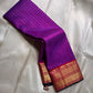 Amethyst Zari Kattam – Pure Kanchipuram Silk Saree
Rich Amethyst Purple Body with Golden Zari Checks
Broad Gold Zari Border with Red Highlights & Temple Motifs
Radiant Ruby Red-Orange Pallu with Lustrous Zari Stripes

Silk Mark Certified, delivery in 2 we