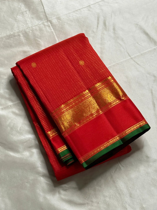 Hema – Bright Red Pure Silk Saree with Golden Zari Kattam
Featuring Baby Buttas and a Green Selvedge for a Subtle Contrast
Red Borders with Vanasringaram & Kamalam Motifs in Fine Zari
(available on pre-order 6 weeks)