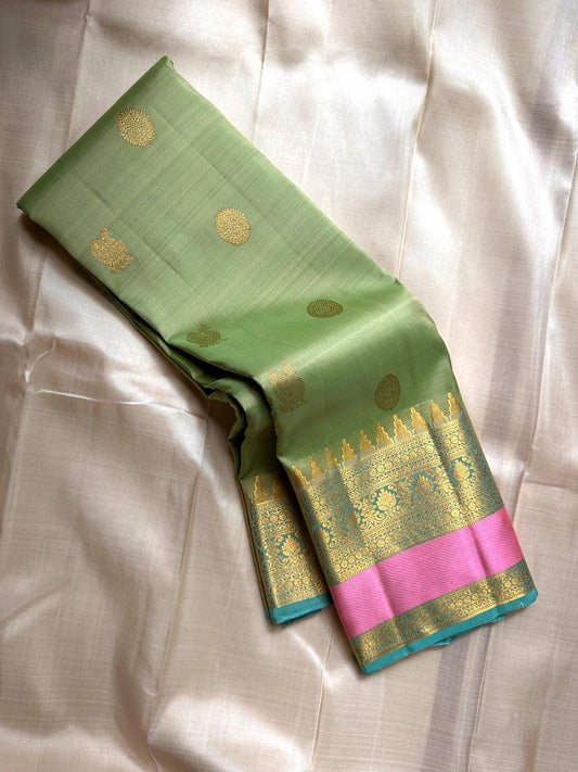 Rose pistachio meadow  – Pure Silk Kanchipuram Saree
Pista Green Body with Coin Paving Mayil Zari Buttas 🦚
Borders in Aqua & Rose with Pillayar Moggu Motifs ✨
Grand Aqua Pallu in All-Over Zari Brocade Weave
Silk Mark Certified | ships in 2 weeks