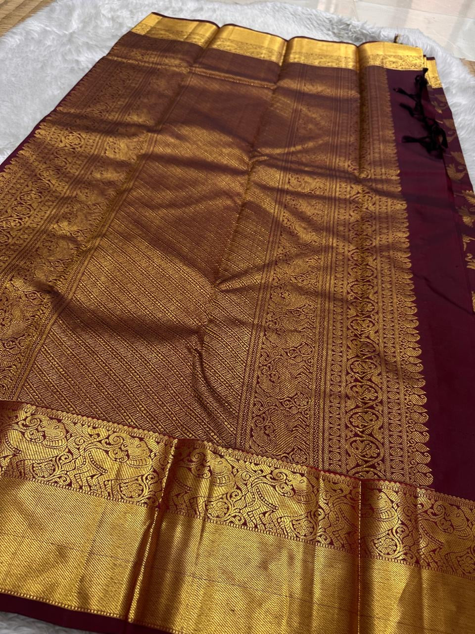 Tanvi – Coffee Brown Kanchipuram Pure Silk Saree with Floral Zari Jaal & Baavanji Border

Rich coffee brown silk adorned with delicate floral zari jaal creates a timeless elegance.
The bold Baavanji border and grand Varisaipettu pallu