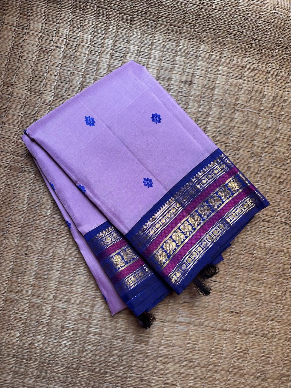 Lilac Indigo Pattu Butta — Pure Kanchipuram Silk Saree
Soft lilac body with indigo flower buttas, rich indigo–magenta gold zari borders and a grand indigo pallu.
Silk Mark Certified • Free Shipping within USA • Ships in Two Weeks